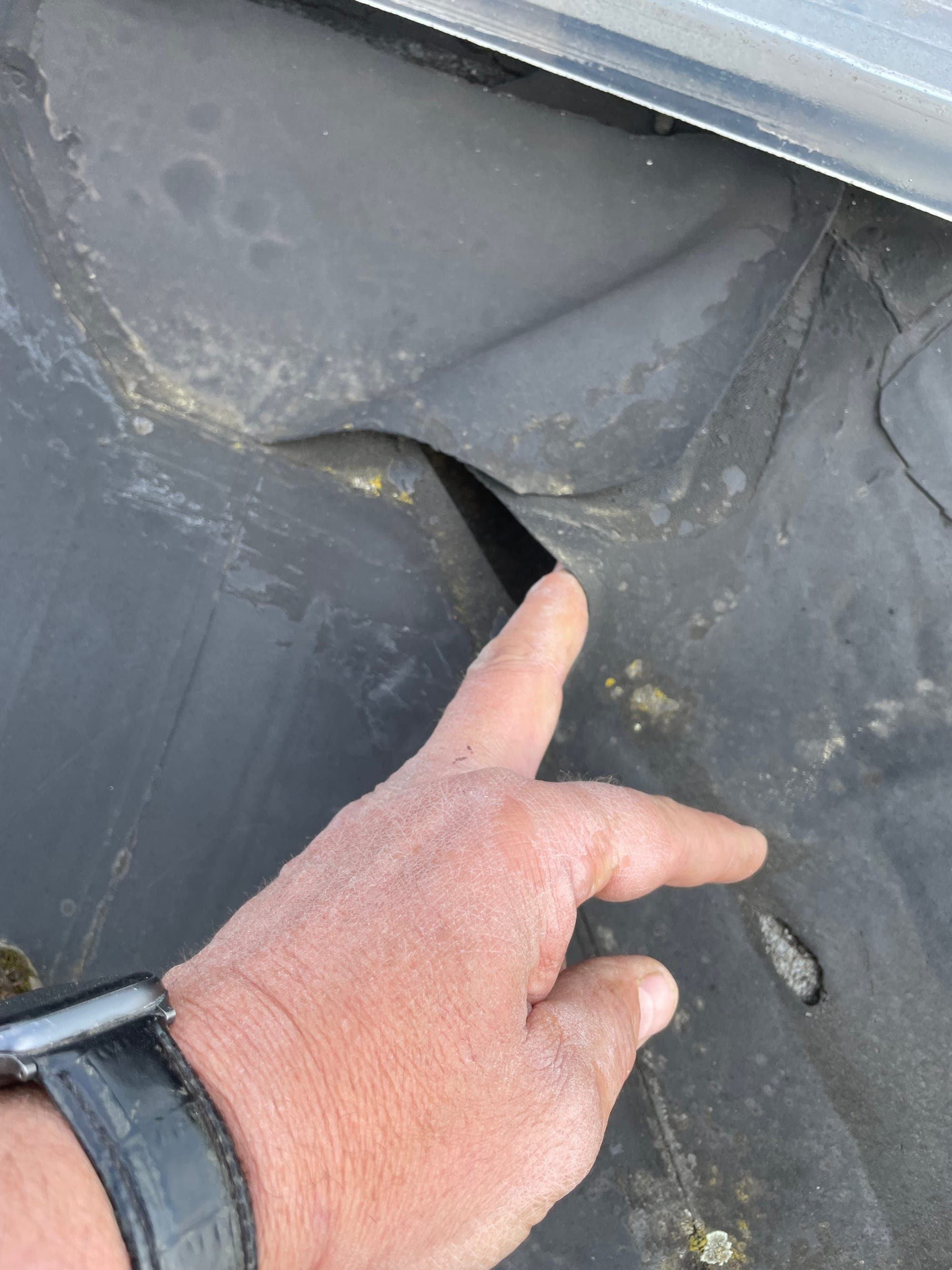 Detail van gescheurd EPDM dak met zichtbaar lek aan de aansluiting