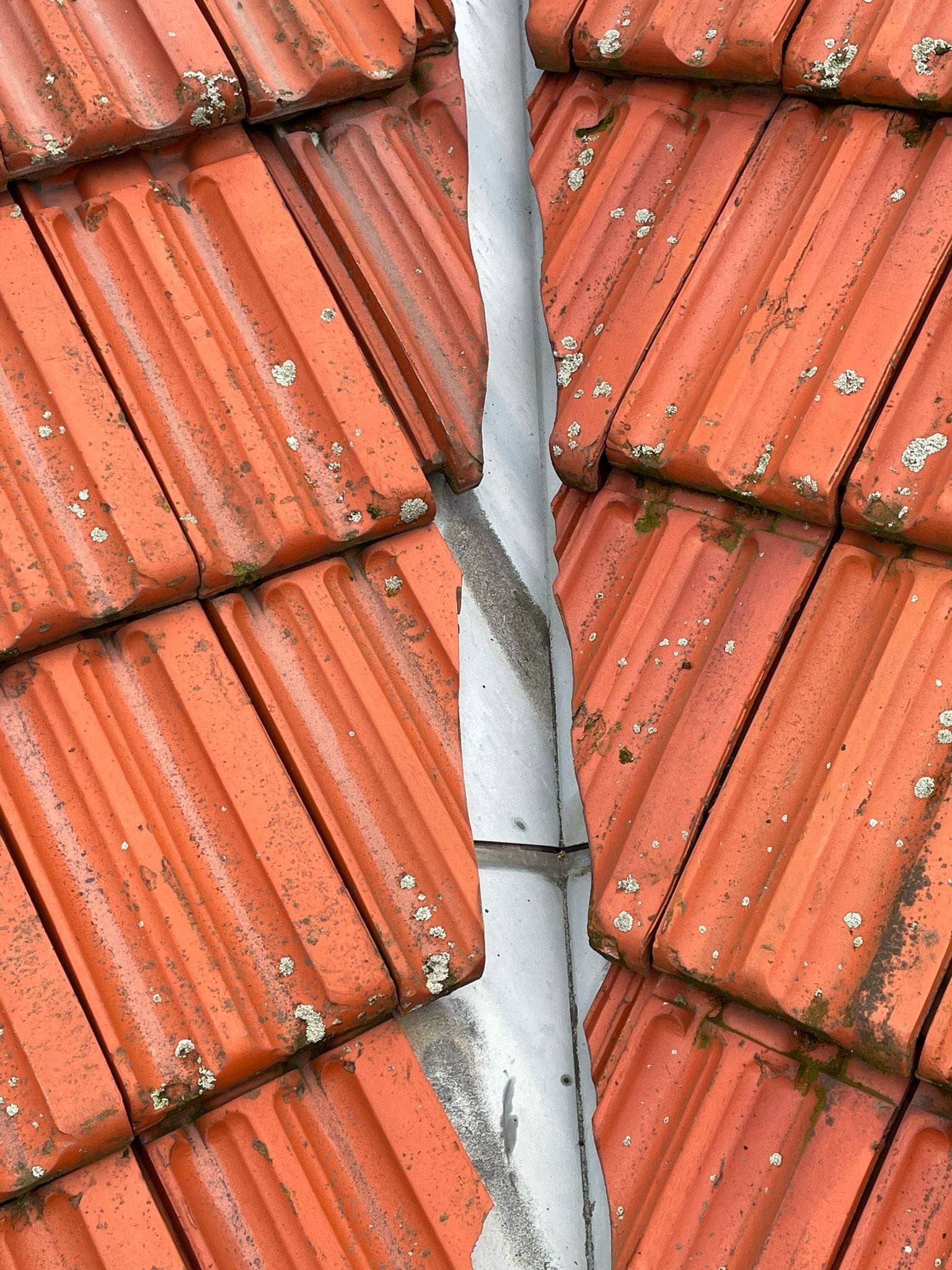 Detail van pannendak met loden kilgoot tussen twee dakvlakken